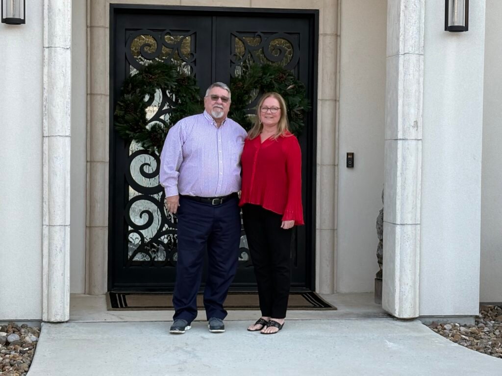 Photo of client standing in front of their custom home built by 919 Custom Homes