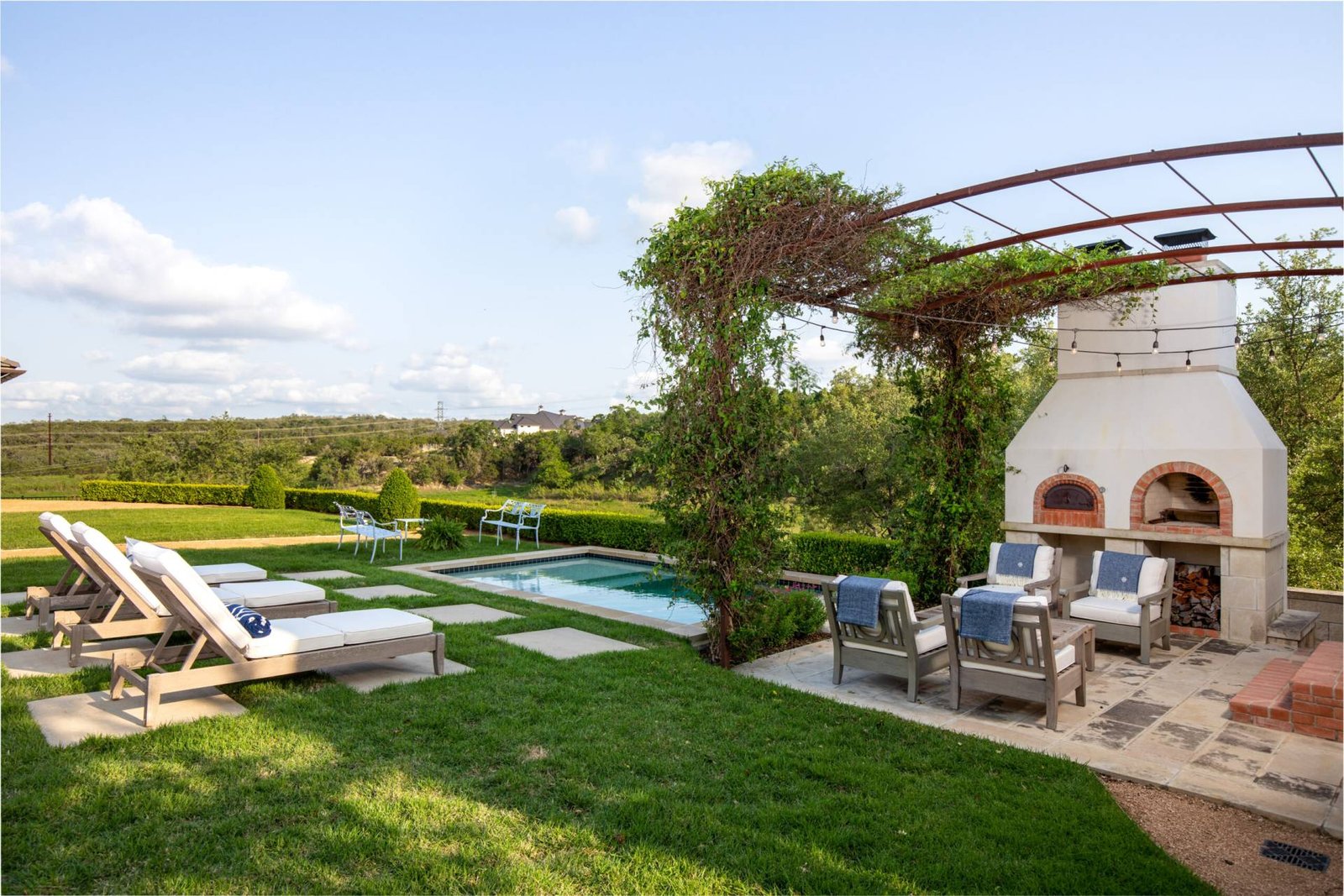 Custom french patio with pool with vintage pergola and fireplace