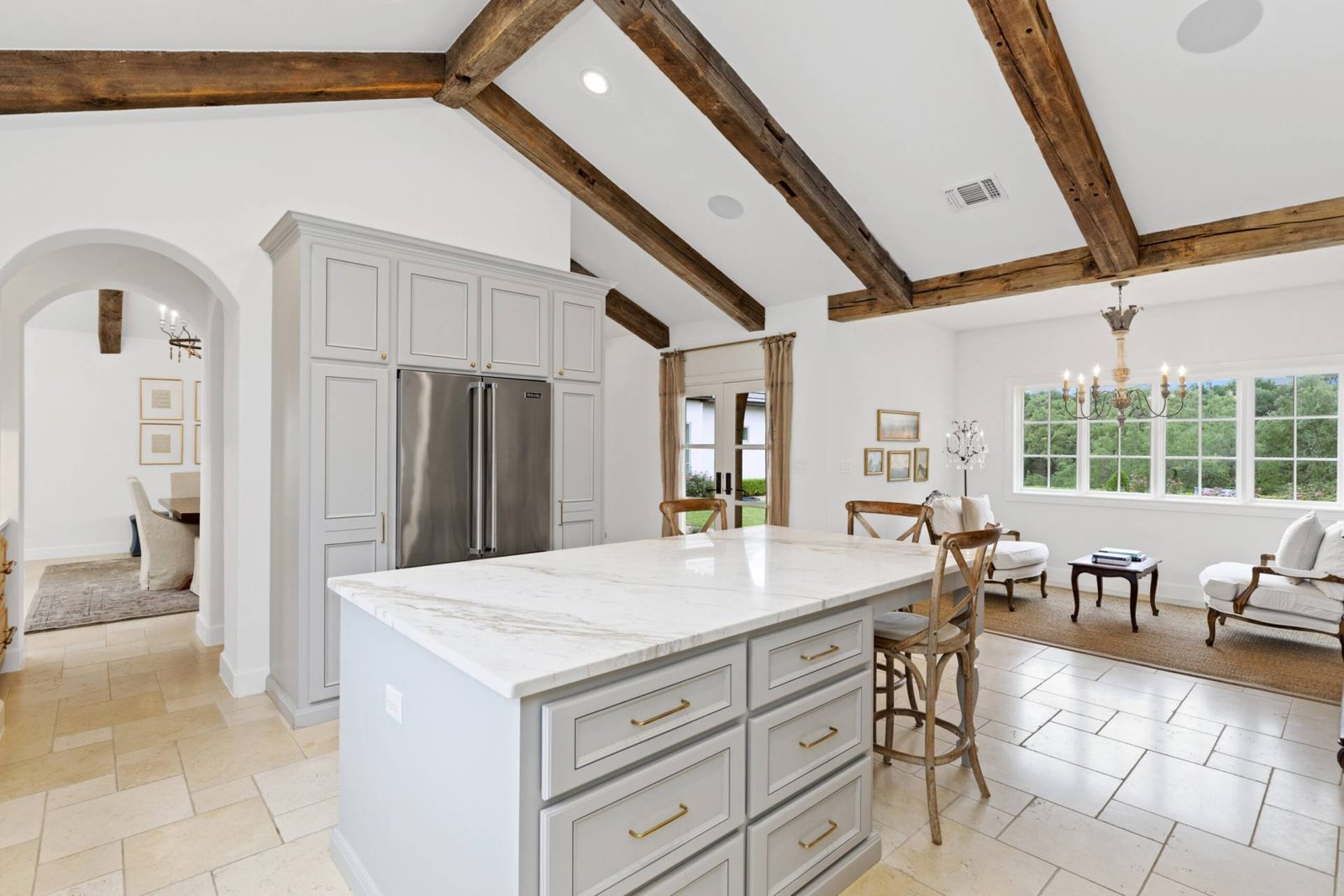 French Country custom home kitchen with custom painted cabinetry quartz countertops farmhouse sink designer hardware and wood beam ceiling by luxury home builder 919 Custom Homes TX